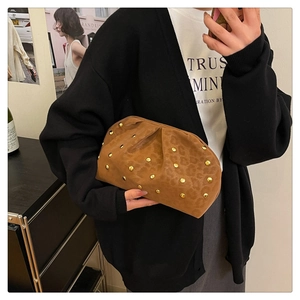 Close-up of leopard print clutch bag with gold rivets and vintage pleat details
