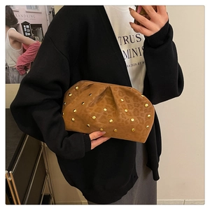 Detailed view of leopard print clutch bag featuring gold studs and pleated cloud texture