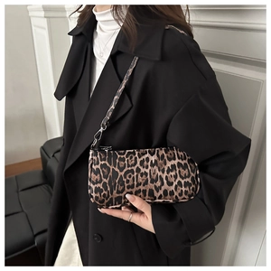 Détail du sac à bandoulière léopard tendance avec finitions argentées sur une tenue chic