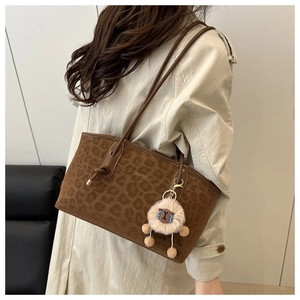 Dettaglio della borsa tote leopardata vintage in finto camoscio con ciondolo a pecora