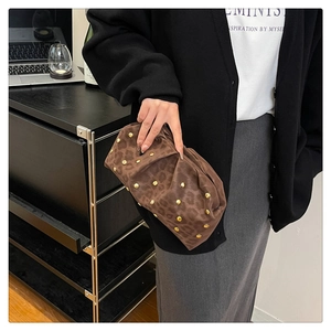 Detail of leopard print clutch with gold studs and soft pleated suede texture