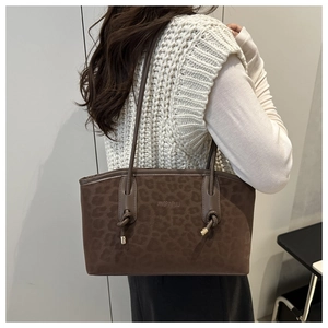 Dettaglio della borsa tote leopardata marrone scuro con logo e sottili spalline da spalla