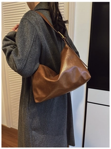 Detail of soft brown PU leather hobo bag with adjustable gold buckle and sleek draping