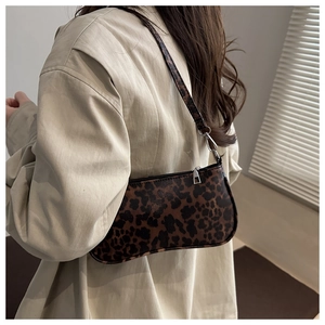 Close-up of leopard print shoulder bag with silver hardware and slim strap detail