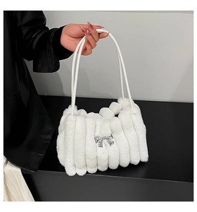 Détail d'un sac à main en peluche blanche avec boucle nœud argenté et fausse fourrure