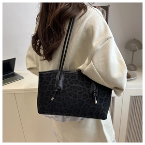 Detail of black leopard print tote bag with shoulder straps and knotted handle design