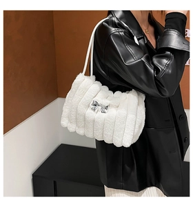 Détails de la texture d'un sac en peluche blanc avec boucle nœud en métal et fausse fourrure