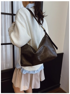 Detail of a dark brown soft leather Hobo bag showing adjustable strap and golden buckle