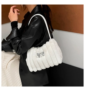 Gros plan du sac bandoulière blanc en peluche avec texture de fourrure et nœud argenté