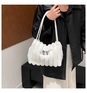 Gros plan d'un sac à bandoulière en fausse fourrure blanche avec nœud argenté chic