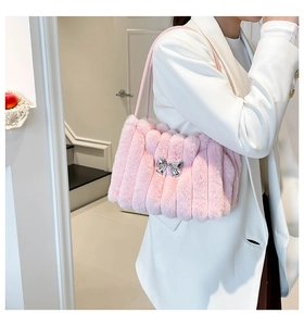 Détail du sac bandoulière en fausse fourrure rose avec nœud argenté et texture douce