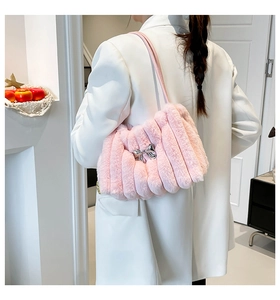 Vue détaillée d'un sac à bandoulière en peluche rose avec boucle nœud en métal argenté