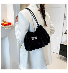 Détail du sac d'épaule en fausse fourrure noire avec texture plissée et nœud argenté