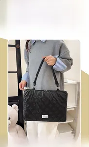 Quilted black laptop tote bag featuring cute bow-tie stitching and fashion label detail