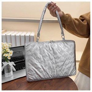 Detail of silver laptop bag featuring butterfly quilting and soft metallic finish
