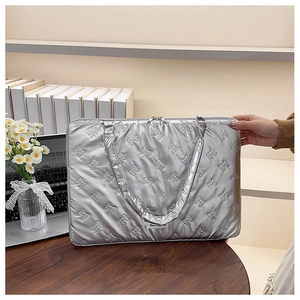 Silver quilted laptop bag with elegant bow patterns and a sleek metallic finish