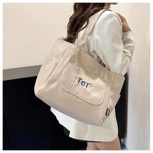 Détail du grand sac cabas beige avec broderie TGT bleue et bandoulière large