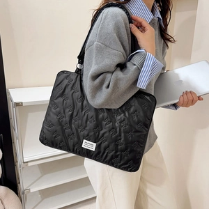Minimalist black quilted laptop bag for women featuring stylish 3D bow patterns and fashion tag