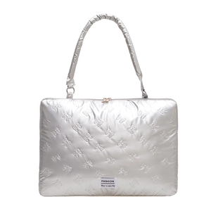 Silver quilted down laptop sleeve with embossed bow patterns and fashion label