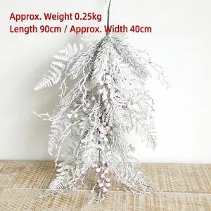 Detailed view of 90cm snow-flocked Christmas swag with red berries and pine needles