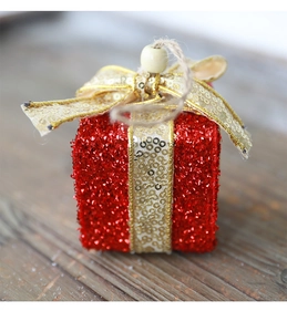 Nahaufnahme der roten Glitzer-Weihnachtsgeschenkbox mit goldener Schleife und Juteband