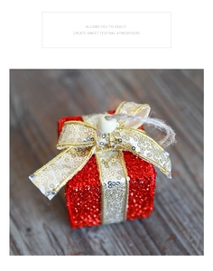Detail eines roten Glitzer-Weihnachtsgeschenks mit goldener Schleife und rustikalem Hanfseil