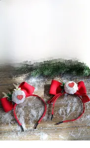 Vue détaillée d'un serre-tête de Noël avec nœuds rouges et bois dorés à paillettes