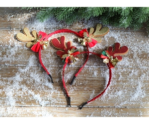 Vue détaillée de trois serre-têtes de renne de Noël avec paillettes et clochettes sur neige