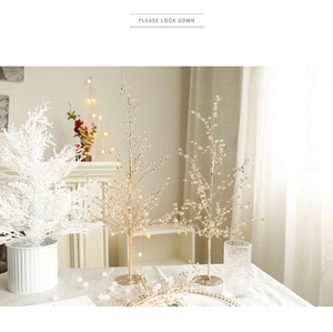 Mini sapin blanc floqué et sapins perlés dorés pour une décoration de table festive chic