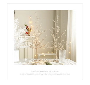Détail de deux sapins de Noël décoratifs dorés avec perles de cristal et effets bokeh