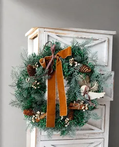 Detail of Christmas wreath with dried lemons, pine cones and a brown velvet bow
