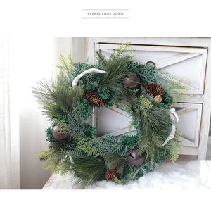 Dettaglio ghirlanda di Natale con pigne e campanelli vintage su sfondo in legno bianco