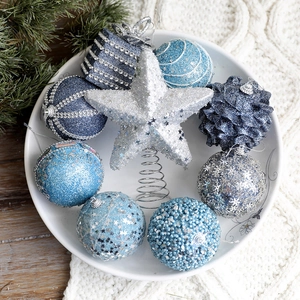 Sky blue and silver Christmas tree ornaments set with star tree topper in a white dish