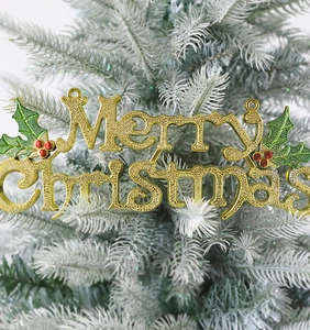 Detail of golden Merry Christmas sign with glitter texture and holly berry accents