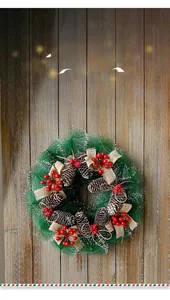 Détail d'une couronne de Noël avec aiguilles de pin, baies rouges et nœud en toile