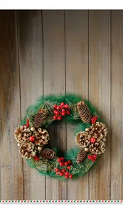 Détail d'une couronne de Noël avec aiguilles de pin, baies rouges et boules dorées