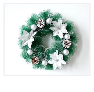 Gros plan d'une couronne de Noël avec aiguilles de pin, fleurs argentées et pommes de pin