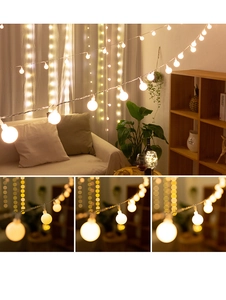 Detail of warm white LED frosted globe string lights in a cozy living room setting