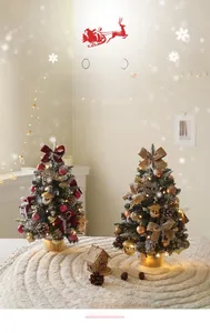 Close-up of two mini snowy Christmas trees with LED lights, bows and wooden bases