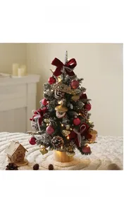 Close-up of a 45cm flocked Christmas tree with red bows and a lit wooden Xmas house