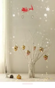 Detailed view of acorn Christmas ornaments in metallic gold and copper hanging on branches