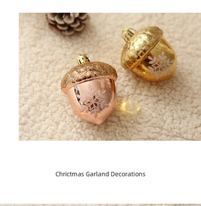 Christmas acorn ornaments with white snowflakes and glitter tops on white faux fur background