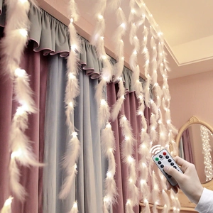 Détail de rideau lumineux LED blanc chaud avec plumes blanches et télécommande sans fil