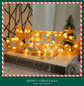 Détail du panneau LED Merry Christmas aux tons chauds avec renne sur des livres déco