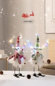 Detail von Plüsch-Rentier-Ornamenten mit LED-Lichtern auf Holzskiern für Weihnachten