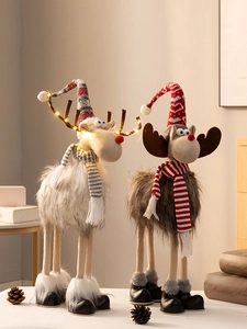 Detail von Plüsch-Weihnachtsrentieren mit warmen LED-Lichtern und Strickschals