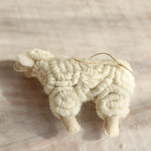Creamy white wool felt sheep ornament with spiral knit texture and rustic jute hanging rope