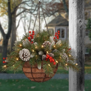 Detail of hanging Christmas basket with pine needles, red berries and warm LED lights
