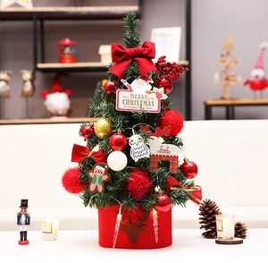 Close-up of mini Christmas tree with red bows, festive ornaments and elk felt base