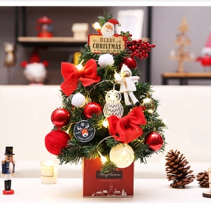 Detail of a 60cm tabletop Christmas tree with red gift box base and warm LED lights